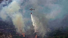 İtalya'nın Sardinya Adası'nda çıkan orman yangınına müdahale eden bir helikopter.