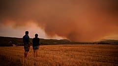 Residents look on as athe forest fire rages near Tarragona.