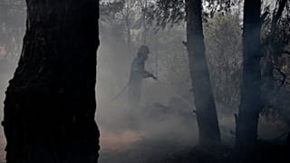 Firefighters battle a wildfire in Dionysos, north east of Athens, on July 27, 2021.