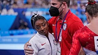 Coach Laurent Landi embraces Simone Biles, after she exited the team final, at the 2020 Summer Olympics, Tuesday, July 27, 2021, in Tokyo