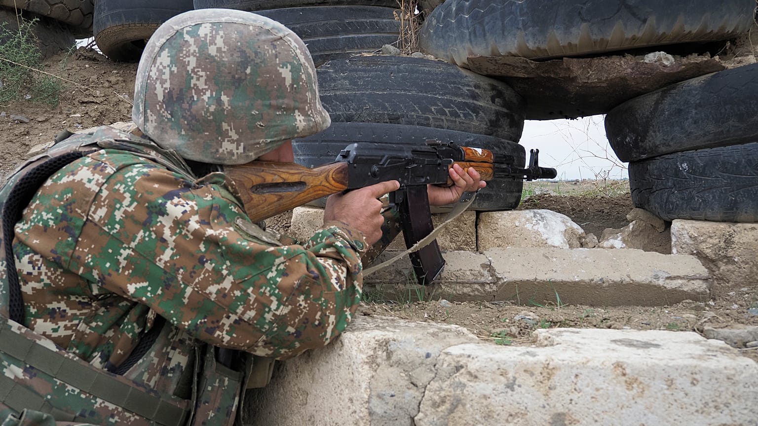 Un soldado armenio sostiene una ametralladora Kalashnikov mientras mira hacia las posiciones de Azerbaiyán