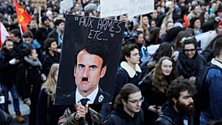 A person holds a placard depicting French President Emmanuel Macron as Adolf Hitler during a 2018 protest against a proposed university reform.