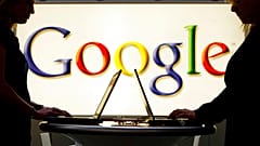 Aussteller arbeiten an Laptops vor einer Leuchtreklame mit dem Google-Logo auf der Industriemesse Hannover Messe in Hannover, 17.04.2007 