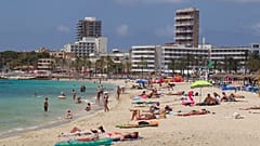 Sonnenanbeter am Strand von Magaluf auf der balearischen Insel Mallorca