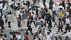 People wearing face masks cross a street in Tokyo