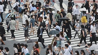 People wearing face masks cross a street in Tokyo