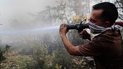 Önkéntes tűzoltó küzd a lángokkal a libanoni Akkar tartományban 2021. július 29-én