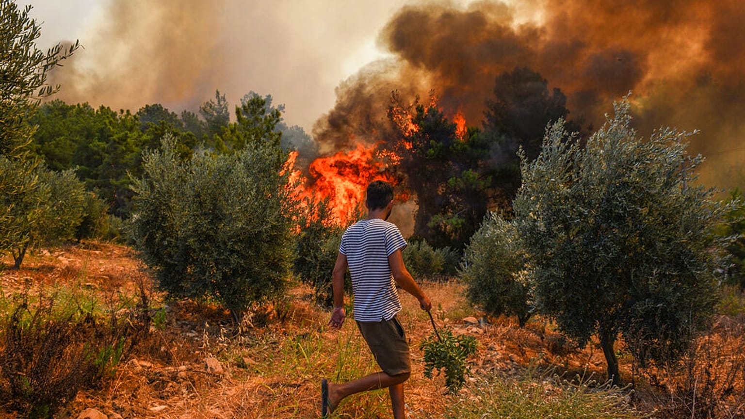 A man walks toward wildfires in Kacarlar village near the Mediterranean coastal town of Manavgat, Antalya, Turkey, Saturday, July 31, 2021.