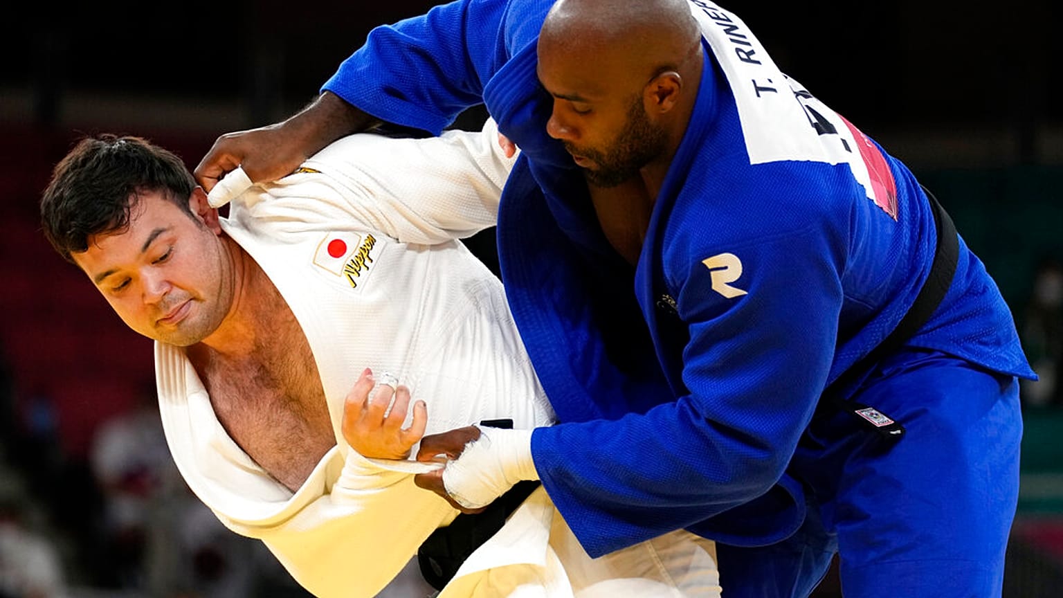 Aaron Wolf of Japan, left, and Teddy Riner of France compete during their gold medal match in team judo competition at the 2020 Summer Olympics, Saturday, July 31, 2021,.
