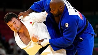 Aaron Wolf of Japan, left, and Teddy Riner of France compete during their gold medal match in team judo competition at the 2020 Summer Olympics, Saturday, July 31, 2021,.
