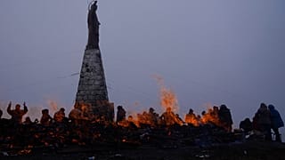 Decenas de personas realizan ofrendas a la Pachamama en La Cumbre, cerca de La Paz, junto a una estatua de Jesucristo.