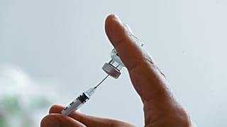A doctor prepares a dose of the Pfizer/BioNTech Covid-19 vaccine at the prefecture in Lille, northern France