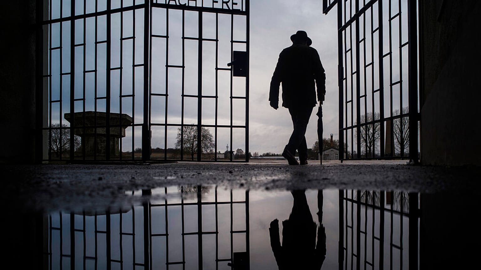 In this Sunday, Jan. 27, 2019 file photo a man walks through the gate of the Sachsenhausen Nazi death camp with the phrase 'Arbeit macht frei' (work sets you free)