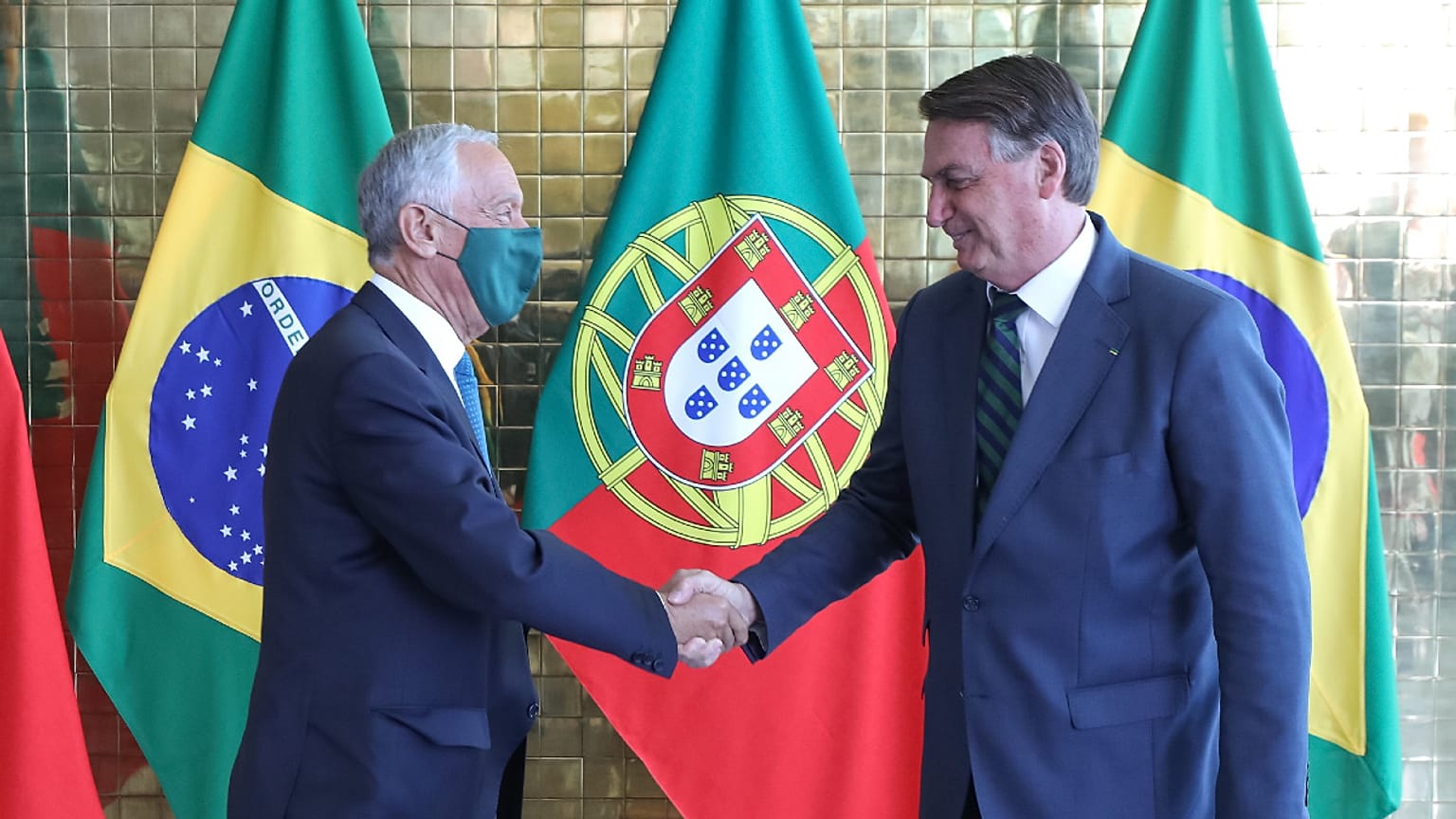 Mareclo Rebelo de Sousa, de máscara, aperta a mão a Jair Bolsonaro, sem máscara