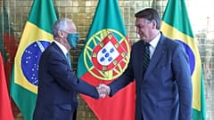 Mareclo Rebelo de Sousa, de máscara, aperta a mão a Jair Bolsonaro, sem máscara
