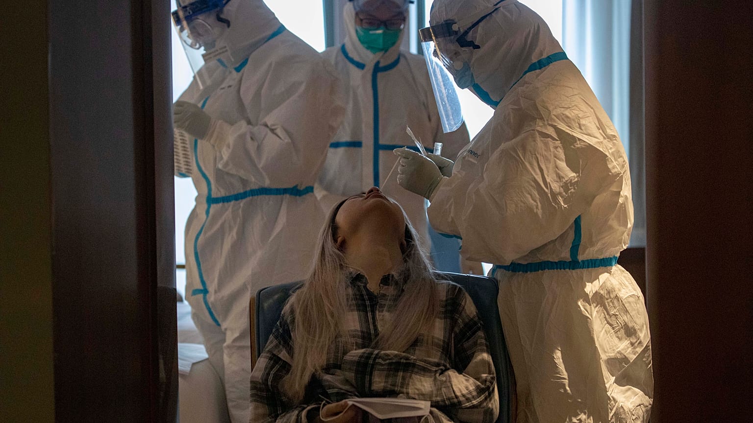 A woman takes a COVID-19 test at a quarantine hotel in Wuhan in central China's Hubei province on Tuesday, March 31, 2020.