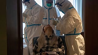 A woman takes a COVID-19 test at a quarantine hotel in Wuhan in central China's Hubei province on Tuesday, March 31, 2020.