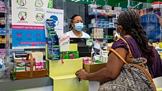 A pharmacist welcomes a client in Pointe-a-Pitre, on the French Caribbean archipelago of Guadeloupe, on July 30, 2021.
