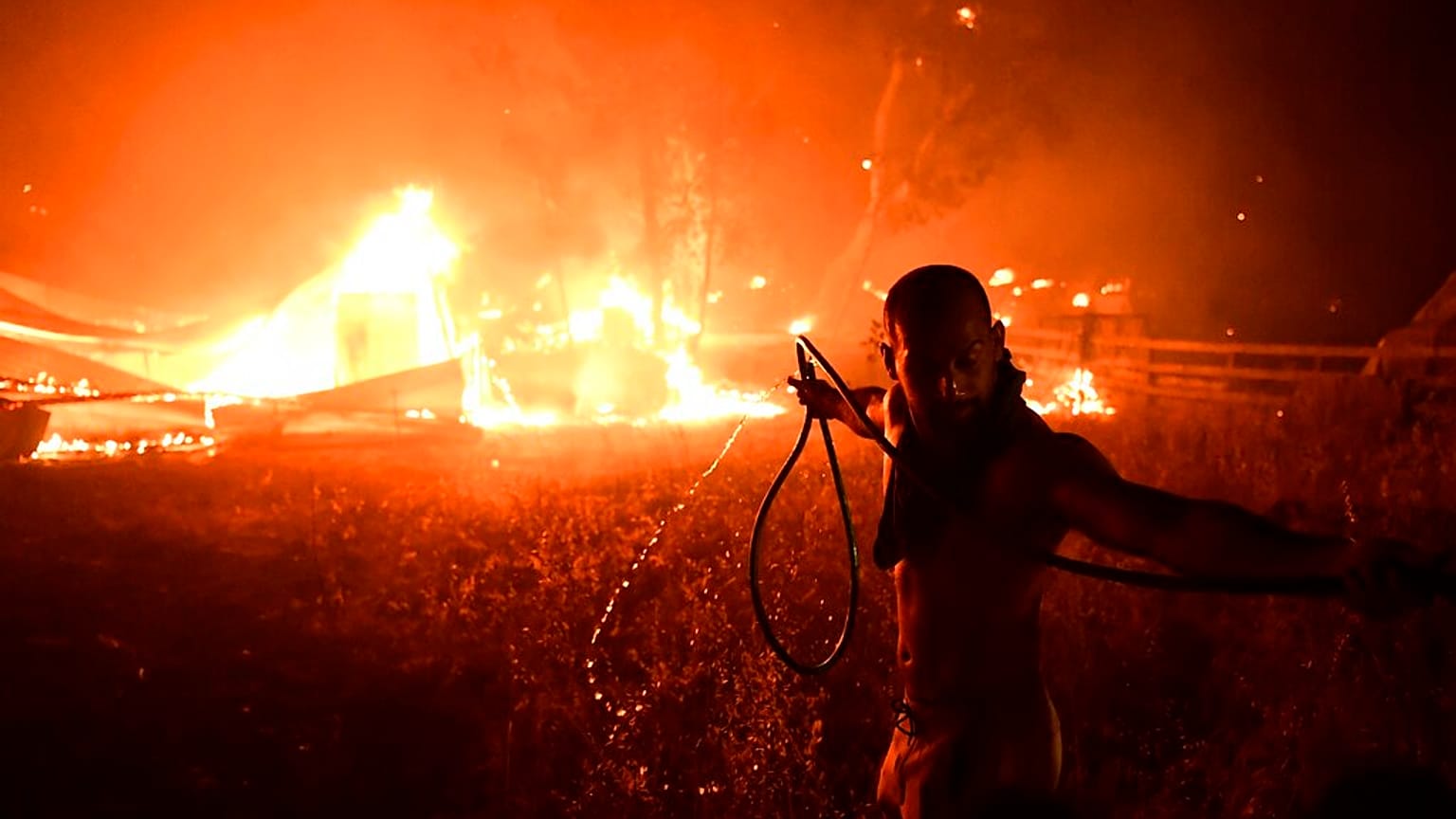 Un hombre lucha contra le fuego en Adames, al norte Atenas, Grecia