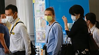 Belarusian Olympic sprinter Krystsina Tsimanouskaya, center, arrives at Narita International Airport in Narita, east of Tokyo Wednesday, Aug. 4, 2021.