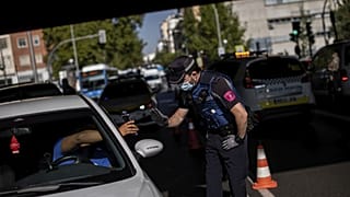 Un agente di polizia locale ferma un veicolo a un posto di blocco a Madrid, Spagna
