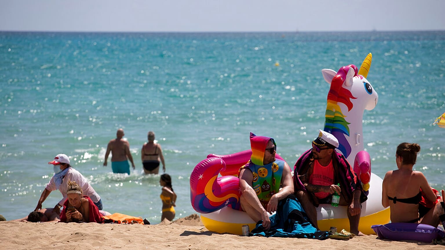 Turistas se bañan y toman el sol en una playa de Mallorca