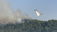 Ελικόπτερο της Πυροσβεστικής πραγματοποιεί ρίψεις νερού κατά τη διάρκεια κατάσβεσης της πυρκαγιάς που μαίνεται στην περιοχή της Λίμνης Εύβοιας,