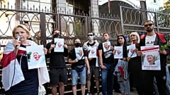 Activists hold portraits of activist Vitaly Shishov, leader of the Belarusian House in Ukraine, during a rally in front of the Belarus Embassy in Kyiv, August 3, 2021. 