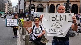 Anti heath pass demonstrators hold placards that read, liberty no to the health pass, outside the Constitutional Council in Paris, Thursday, Aug. 5,2021