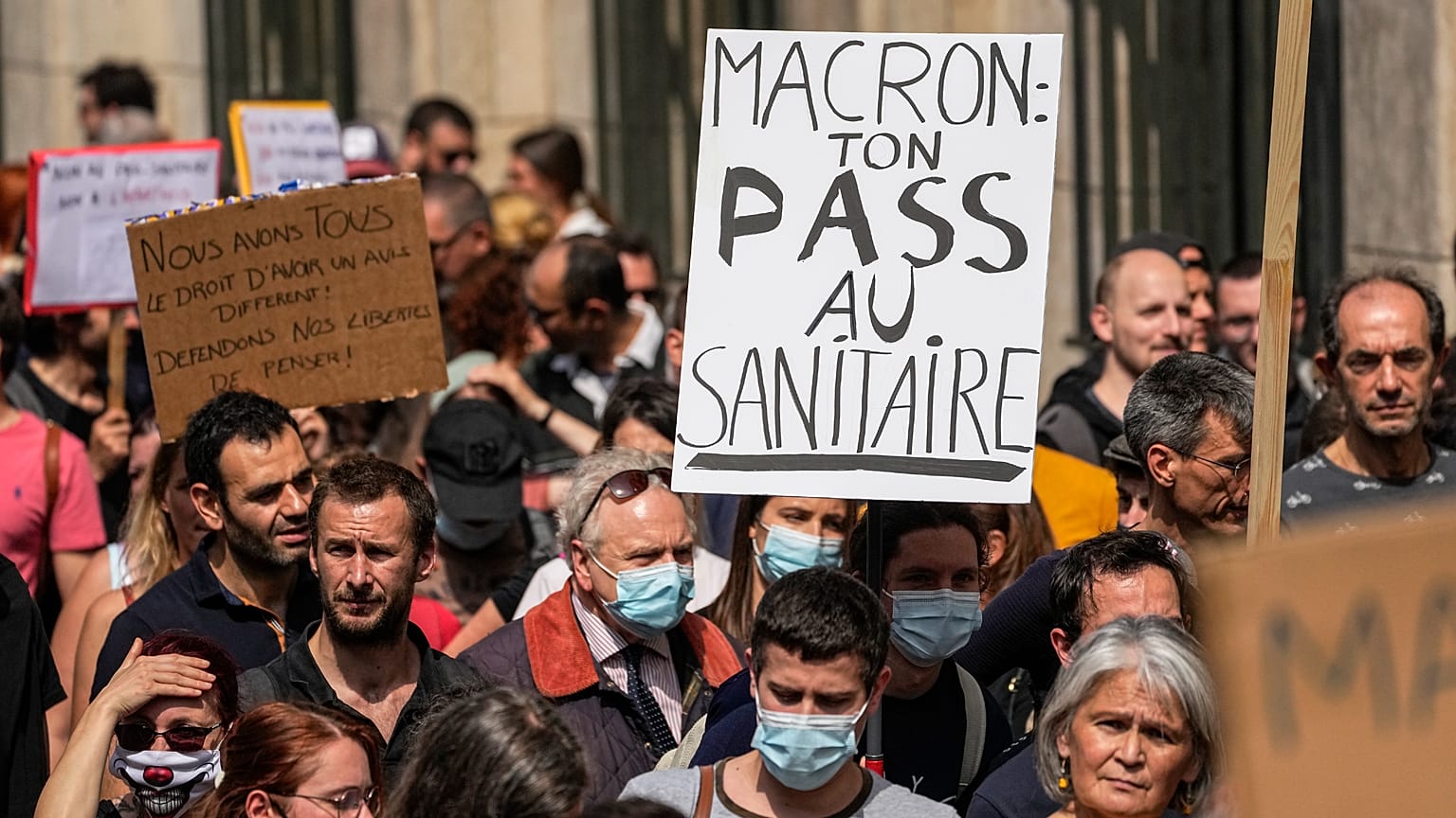 Un manifestante antivacunas sostiene una pancarta en la que se lee "Macron tu salud entra por el inodoro" durante una manifestación en París, el 17 de julio de 2021.