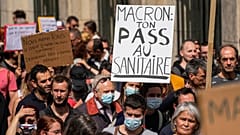 Un manifestante antivacunas sostiene una pancarta en la que se lee "Macron tu salud entra por el inodoro" durante una manifestación en París, el 17 de julio de 2021.