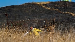 An Israeli firefighter attempts to extinguish a fire caused by rocket fired from Lebanon into Israeli territory near the northern Israeli town of Kiryat Shmona.