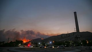 حريق غابات، في الخلف يساراً ، يقترب من محطة كيميركوي الحرارية للطاقة على اليمين، في ميلاس، موغلا، تركيا، الثلاثاء 3 آب/ أغسطس، 2021.