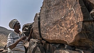 إبراهيم دابل، وهو يفسر النقوش على الصخور البركانية للحياة البرية.
