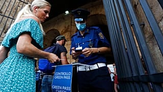 Сотрудники службы безопасности проверяют у посетителей "зелёный паспорт" на входе в Колизей в Риме