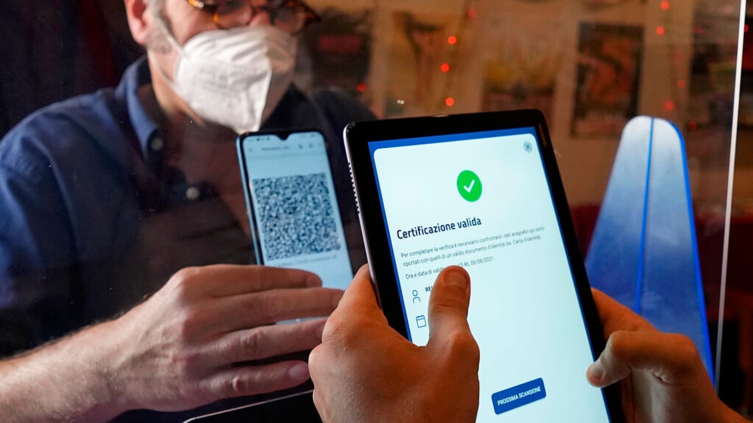 A customer has his "green pass" checked at the entrance of a cinema in Milan, Italy,