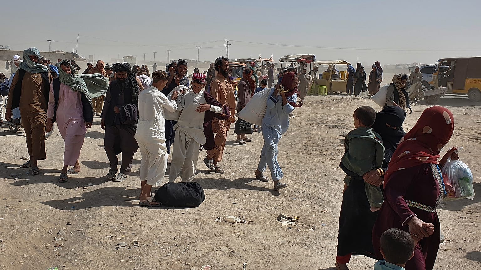 Stranded people gather and wait to open the border which was closed by authorities, in Chaman, Pakistan, Aug. 7, 2021.