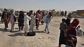 Stranded people gather and wait to open the border which was closed by authorities, in Chaman, Pakistan, Aug. 7, 2021.