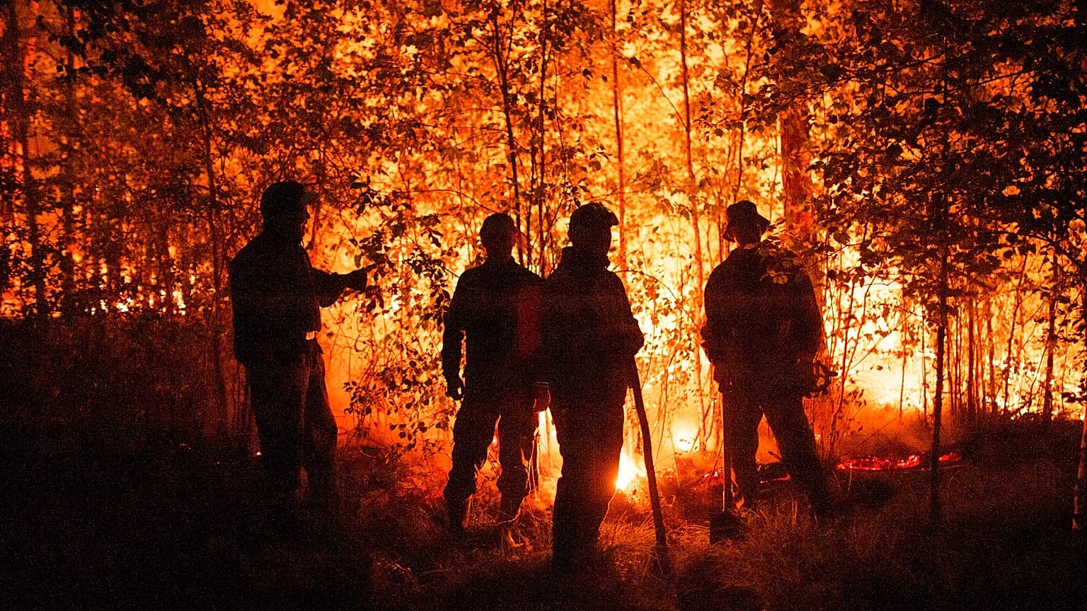 Firefighters work at the scene of forest fire near Kyuyorelyakh village at Gorny Ulus area, west of Yakutsk, in Russia, Aug. 5, 2021. 