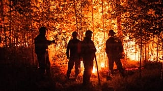 Firefighters work at the scene of forest fire near Kyuyorelyakh village at Gorny Ulus area, west of Yakutsk, in Russia, Aug. 5, 2021. 