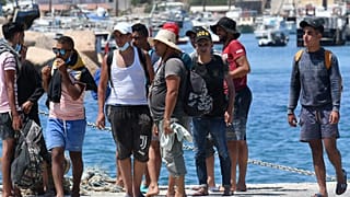 Migrants from Tunisia disembark from a 'Guardia di Finanza' patrol boat, on the Italian Pelagie Island of Lampedusa on August 1, 2020.
