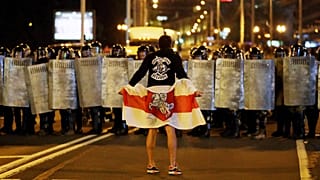 A protester faces police on 9 August 2020 in Minsk, Belarus