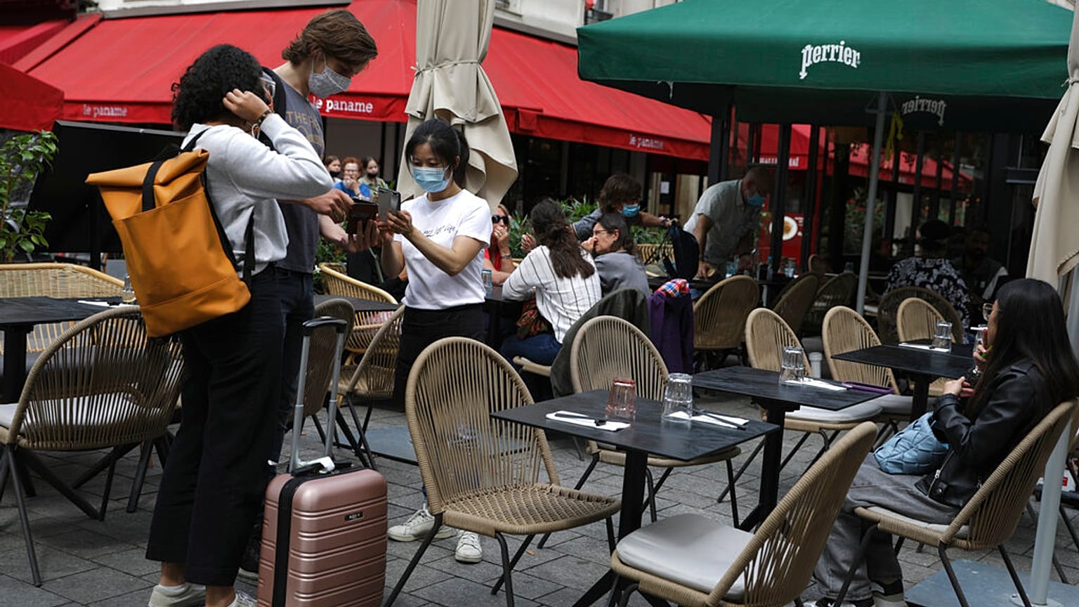 Una cameriera controlla il pass sanitario dei clienti in un ristorante a Parigi
