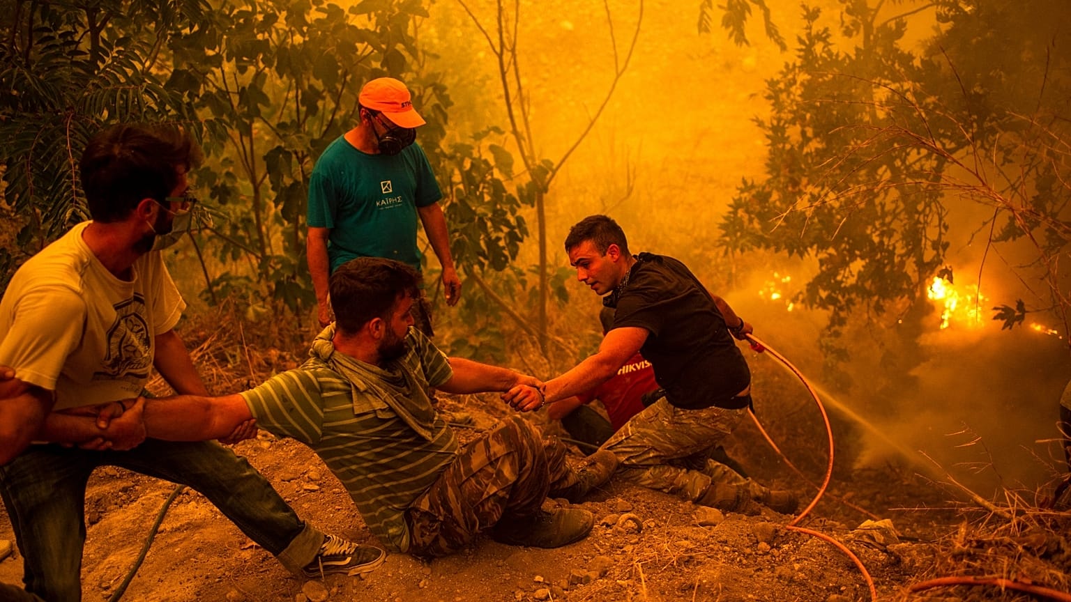 Local residents fight wildfires in the village of Gouves on Evia (Euboea) island.