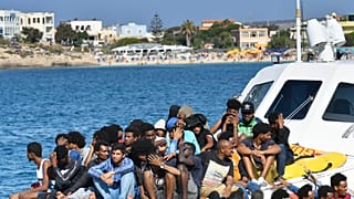 Migrants from Tunisia and Lybia arrive onboard of an Italian Guardia Costiera (Coast Guard) boat in the Italian Pelagie Island of Lampedusa on August 1, 2020.