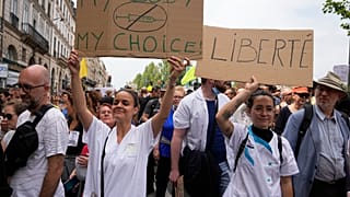 Des infirmières et leur panneau lors d'une manifestation anti-pass sanitaire à Paris le 17 juillet 2021