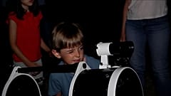 Un niño mira por un telescopio 