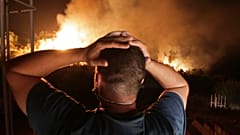 ينظر رجل إلى حريق غابة بالقرب من قرية أربا ناث إراثن في تيزي وزو بمنطقة القبائل الجبلية- 11 آب / أعسطش 2021
