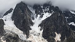 This picture taken in the Mont Blanc Massif, on August 3, 2021 shows a serac raising a snow cloud as falls downstream from Grandes Jorasses.
