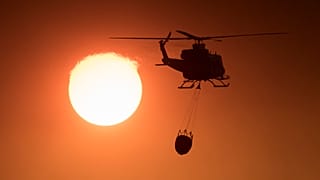 Пожарный вертолёт в задымлённом небе Андалусии